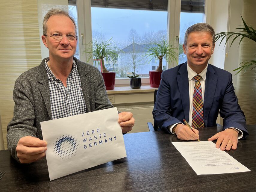 Hubertus Abraham und Landrat Michael Stickeln sitzen an einem Schreibtisch.