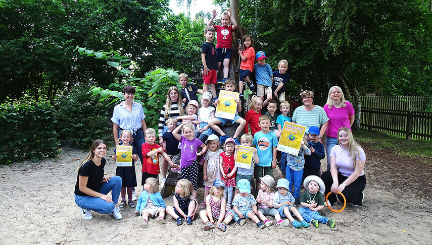 Stolz zeigen die Kinder mit Mitarbeitenden der Kita Buddelkiste in Steinheim die Kindermeilen-Urkunden.